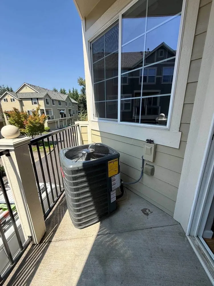 Outdoor condenser on a balcony beside a window